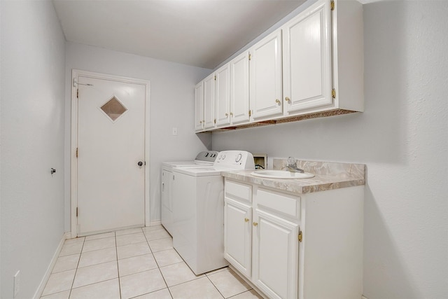 laundry room with independent washer and dryer, cabinets, sink, and light tile patterned floors