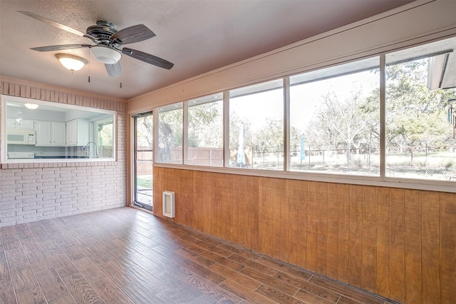 unfurnished sunroom with ceiling fan and sink