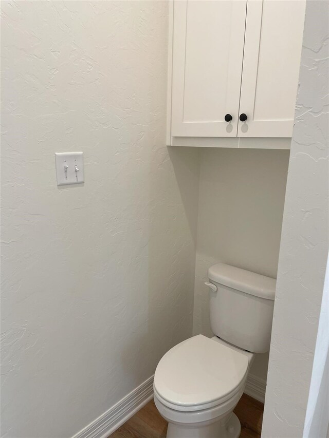 bathroom with toilet and wood-type flooring