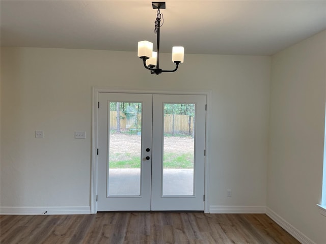 doorway to outside with a notable chandelier, french doors, and light hardwood / wood-style floors