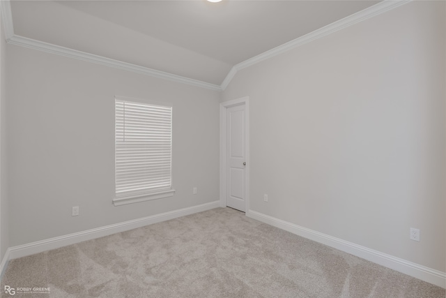 carpeted empty room featuring vaulted ceiling and ornamental molding