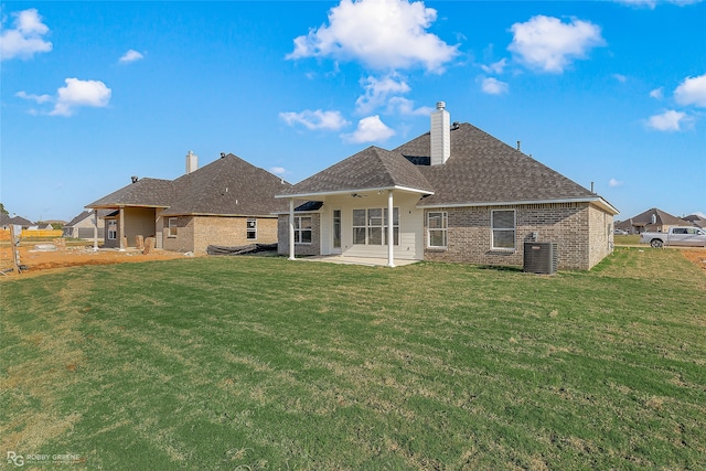 rear view of house with central AC, ceiling fan, a patio area, and a lawn