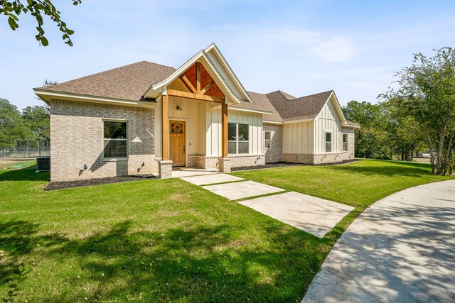 view of front of property featuring cooling unit and a front yard