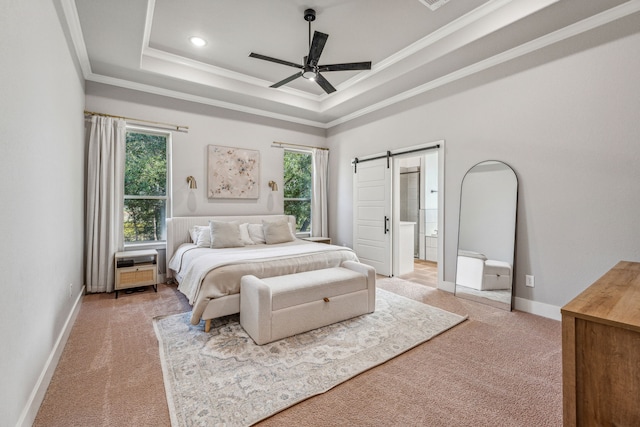 carpeted bedroom with a barn door, a raised ceiling, ornamental molding, and ceiling fan