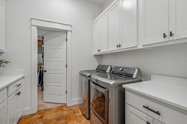 clothes washing area with light carpet, cabinets, and washing machine and dryer