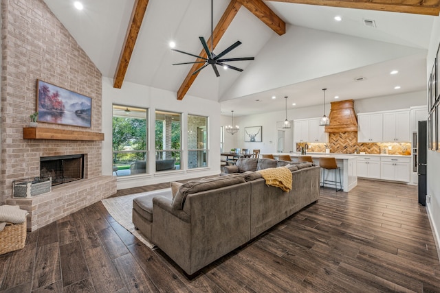 living room featuring a brick fireplace, beamed ceiling, dark hardwood / wood-style floors, and high vaulted ceiling