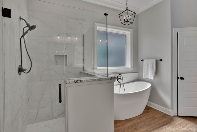 bathroom featuring ornamental molding, hardwood / wood-style flooring, independent shower and bath, and a notable chandelier