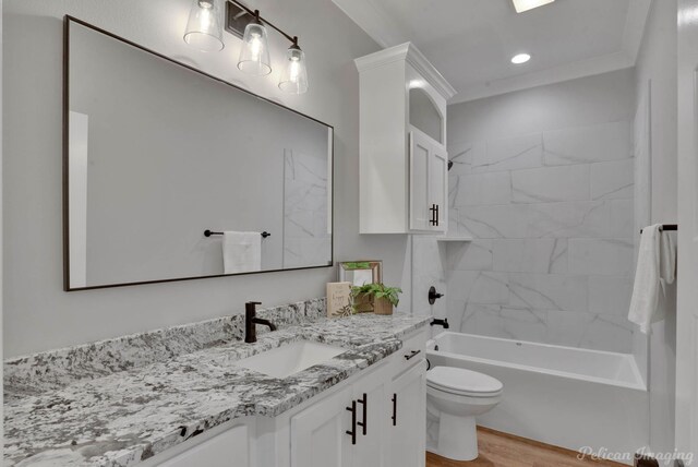 full bathroom with vanity, crown molding, hardwood / wood-style flooring, toilet, and tiled shower / bath