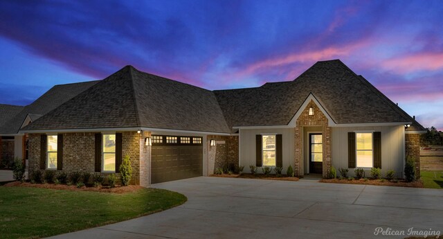 view of front of home with a garage and a yard