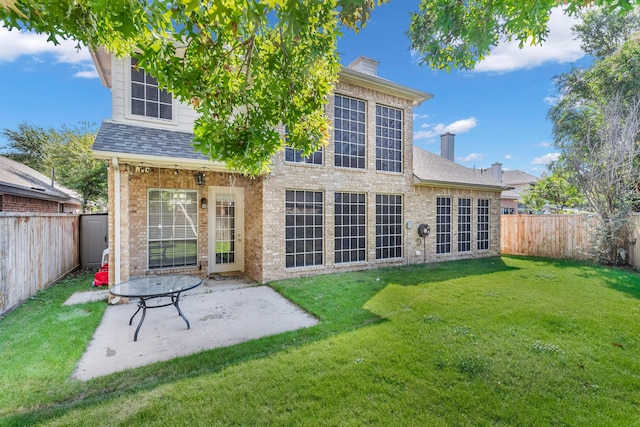 back of house featuring a patio and a yard