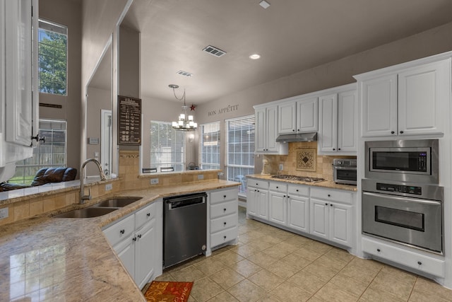 kitchen with stainless steel appliances, a chandelier, white cabinets, and sink