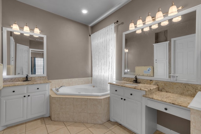 bathroom featuring tile patterned floors, vanity, and tiled bath