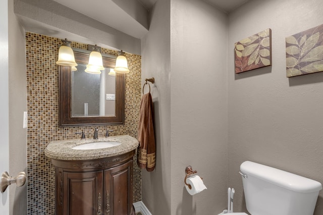 bathroom with vanity, backsplash, and toilet