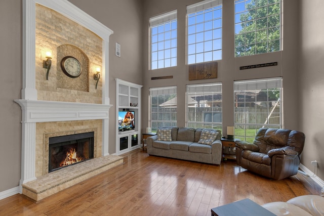 living room with a wealth of natural light, a towering ceiling, and wood-type flooring