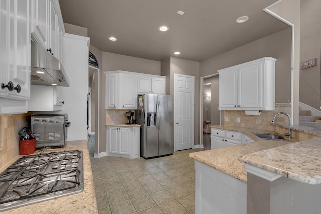 kitchen featuring stainless steel appliances, backsplash, sink, and white cabinetry