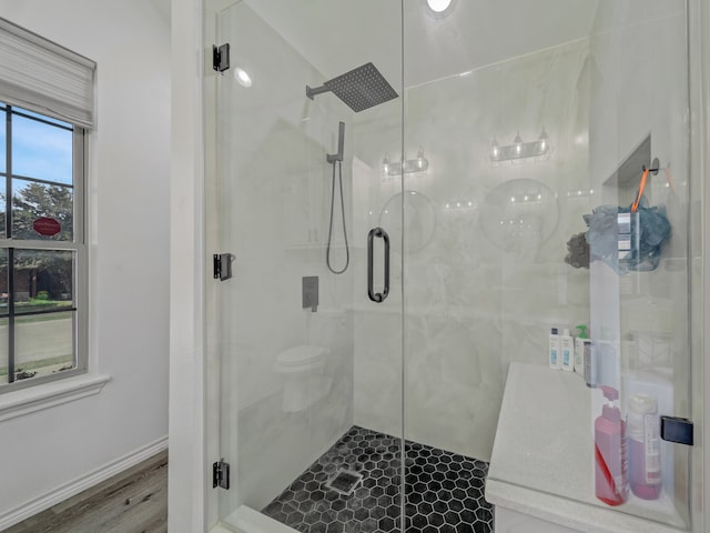 bathroom with wood-type flooring and a shower with shower door