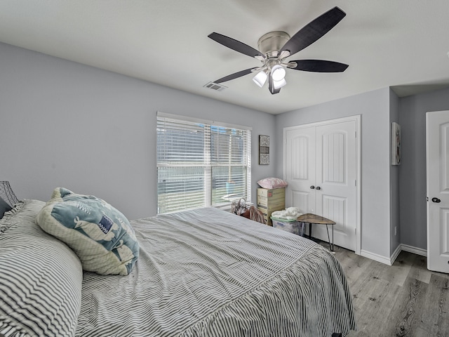 bedroom with a closet, light hardwood / wood-style floors, and ceiling fan