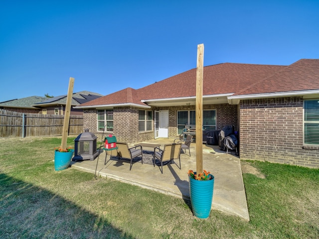 back of house featuring a lawn and a patio