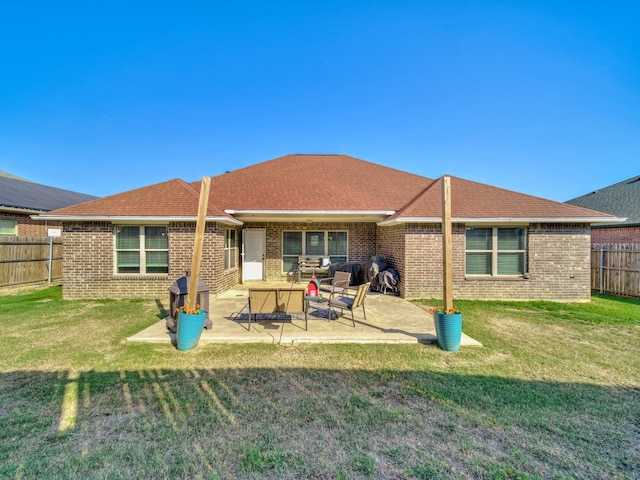 rear view of property featuring a lawn and a patio