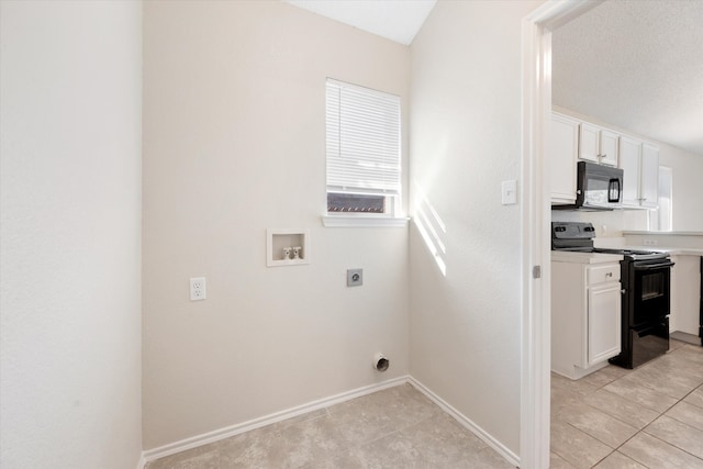 laundry area with hookup for an electric dryer, hookup for a washing machine, light tile patterned floors, and a textured ceiling