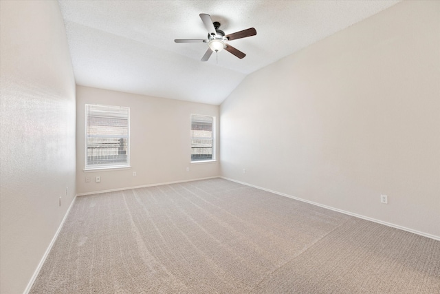 spare room with lofted ceiling, ceiling fan, and light colored carpet