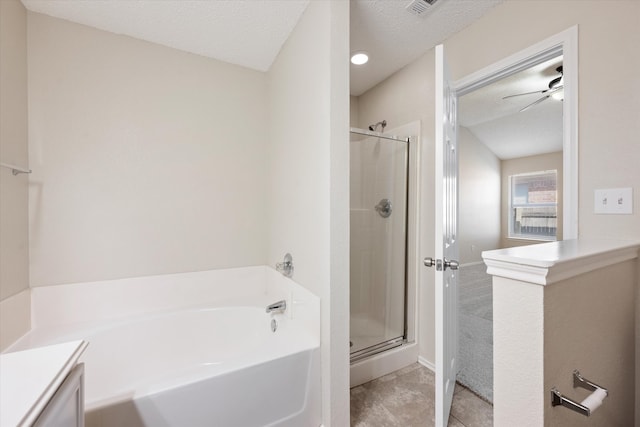 bathroom featuring ceiling fan, vanity, plus walk in shower, and a textured ceiling