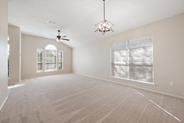 unfurnished living room with ceiling fan with notable chandelier, vaulted ceiling, a textured ceiling, and light carpet