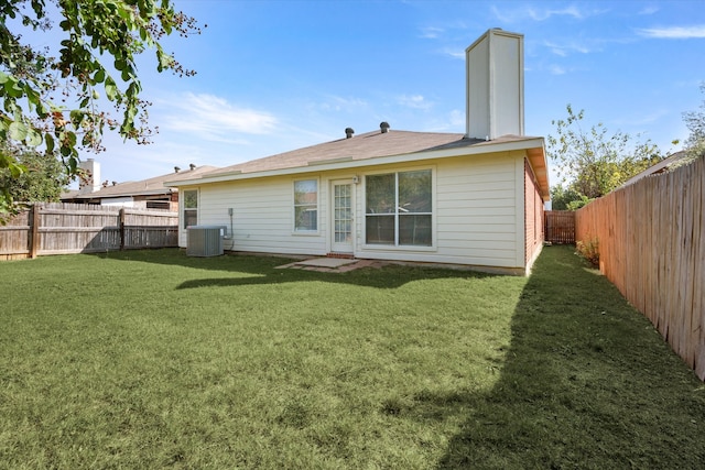 rear view of house featuring a yard and central AC