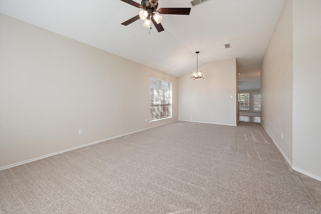 carpeted spare room featuring ceiling fan with notable chandelier and lofted ceiling