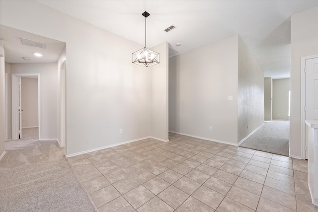 spare room with light carpet and an inviting chandelier