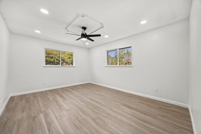 empty room featuring plenty of natural light, light wood-type flooring, and ceiling fan