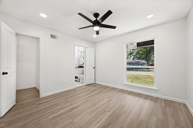 unfurnished bedroom with ceiling fan, light hardwood / wood-style flooring, ensuite bath, and a closet