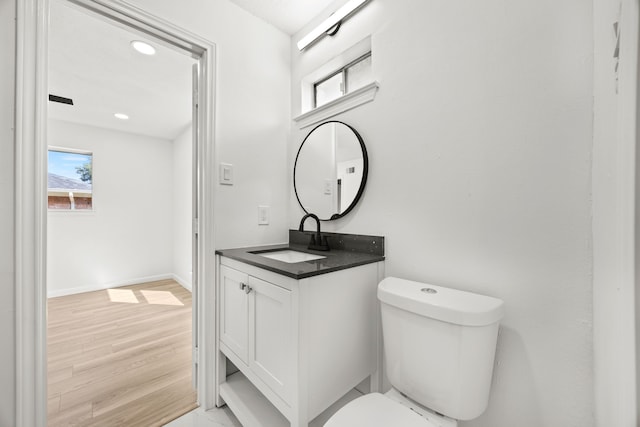 bathroom featuring vanity, hardwood / wood-style flooring, and toilet