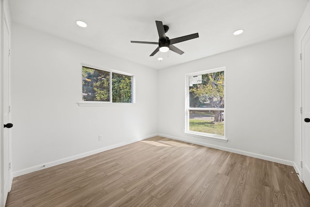 unfurnished room featuring plenty of natural light, wood-type flooring, and ceiling fan