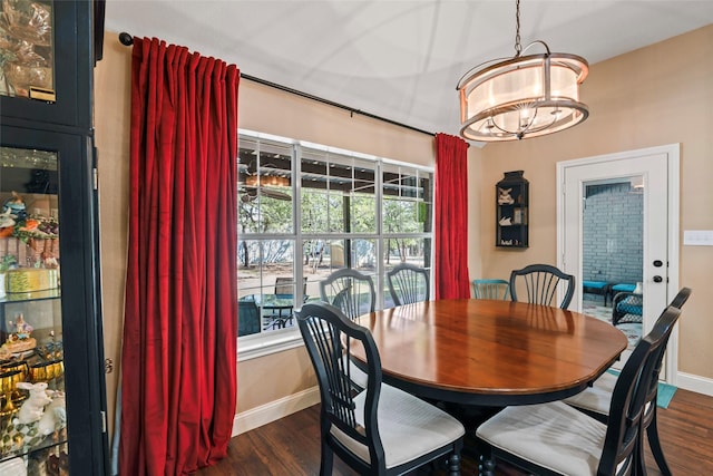 dining space with dark wood-type flooring and a notable chandelier