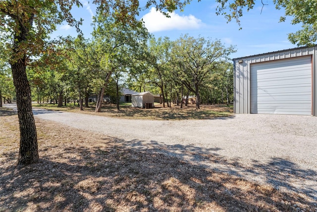 view of yard featuring a garage and an outdoor structure