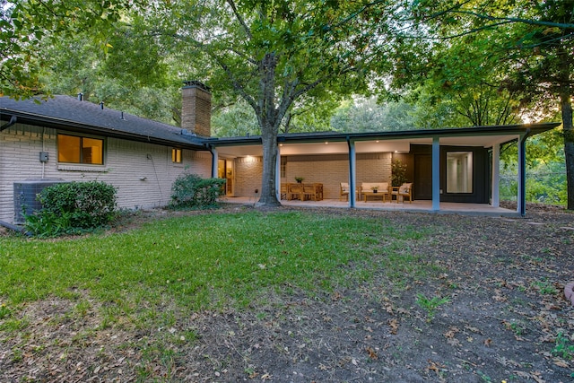 back of property with a yard, central AC, and a patio area