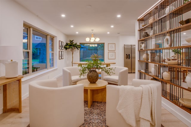 living room with an inviting chandelier and light hardwood / wood-style flooring