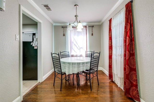 dining area featuring a notable chandelier, crown molding, and dark hardwood / wood-style flooring