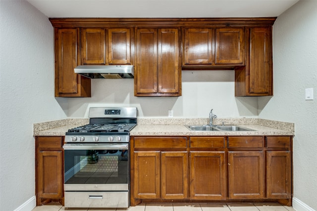 kitchen with gas range, sink, and light tile patterned floors