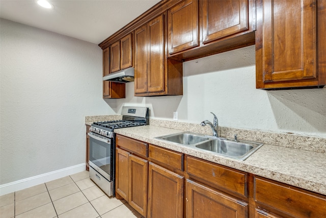 kitchen featuring stainless steel gas range, sink, and light tile patterned floors