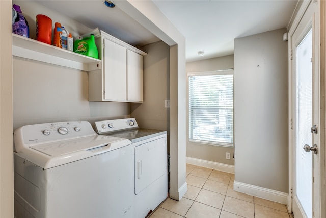 laundry room with independent washer and dryer, light tile patterned floors, and cabinets