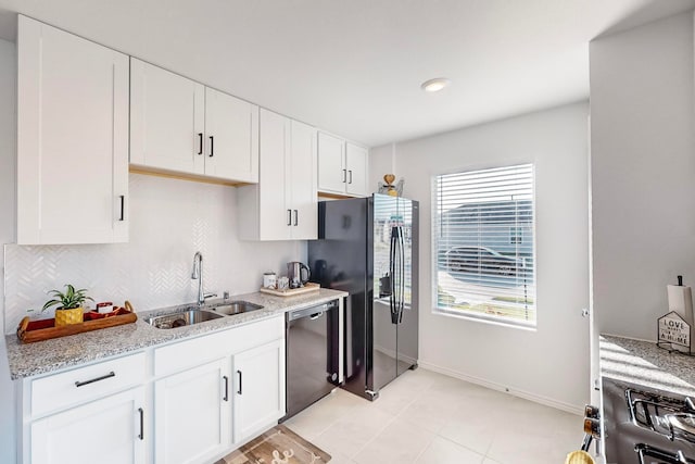 kitchen featuring dishwasher, light stone countertops, sink, and white cabinetry