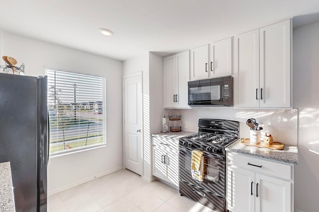 kitchen featuring light stone counters, white cabinetry, and black appliances