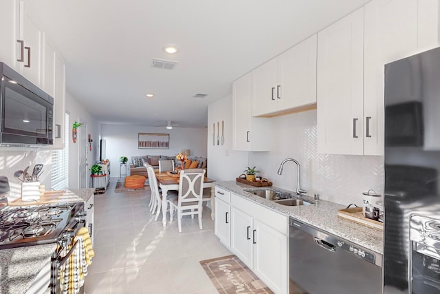 kitchen with light stone countertops, sink, white cabinetry, and black appliances