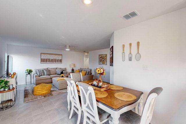 tiled dining space with ceiling fan