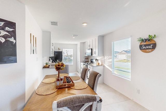 dining area with light tile patterned flooring, a healthy amount of sunlight, and sink