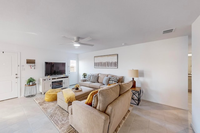 living room featuring ceiling fan, light tile patterned flooring, and a fireplace