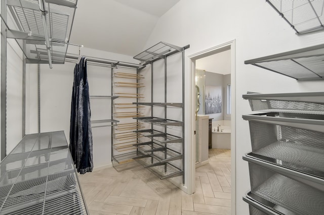 walk in closet with light parquet floors