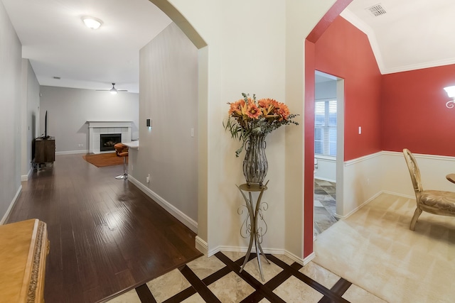 corridor with hardwood / wood-style floors and ornamental molding